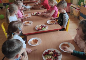 Dzieci wykonują deser lodowo- owocowy.